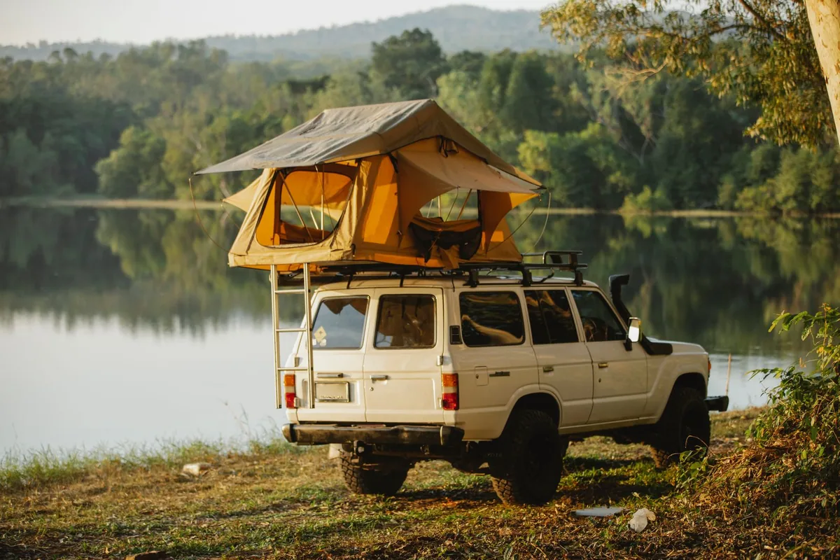 4x4 with rooftop tent beside water for a weekend trail camp